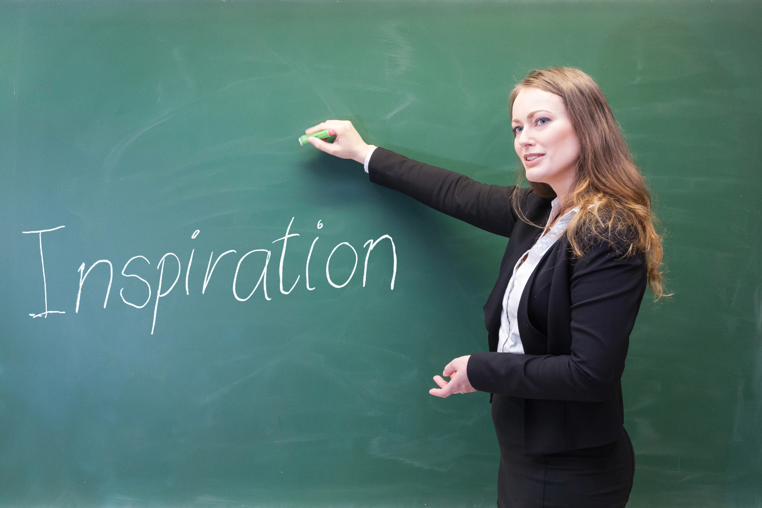 Kvinde skriver på tavle: "Inspiration"