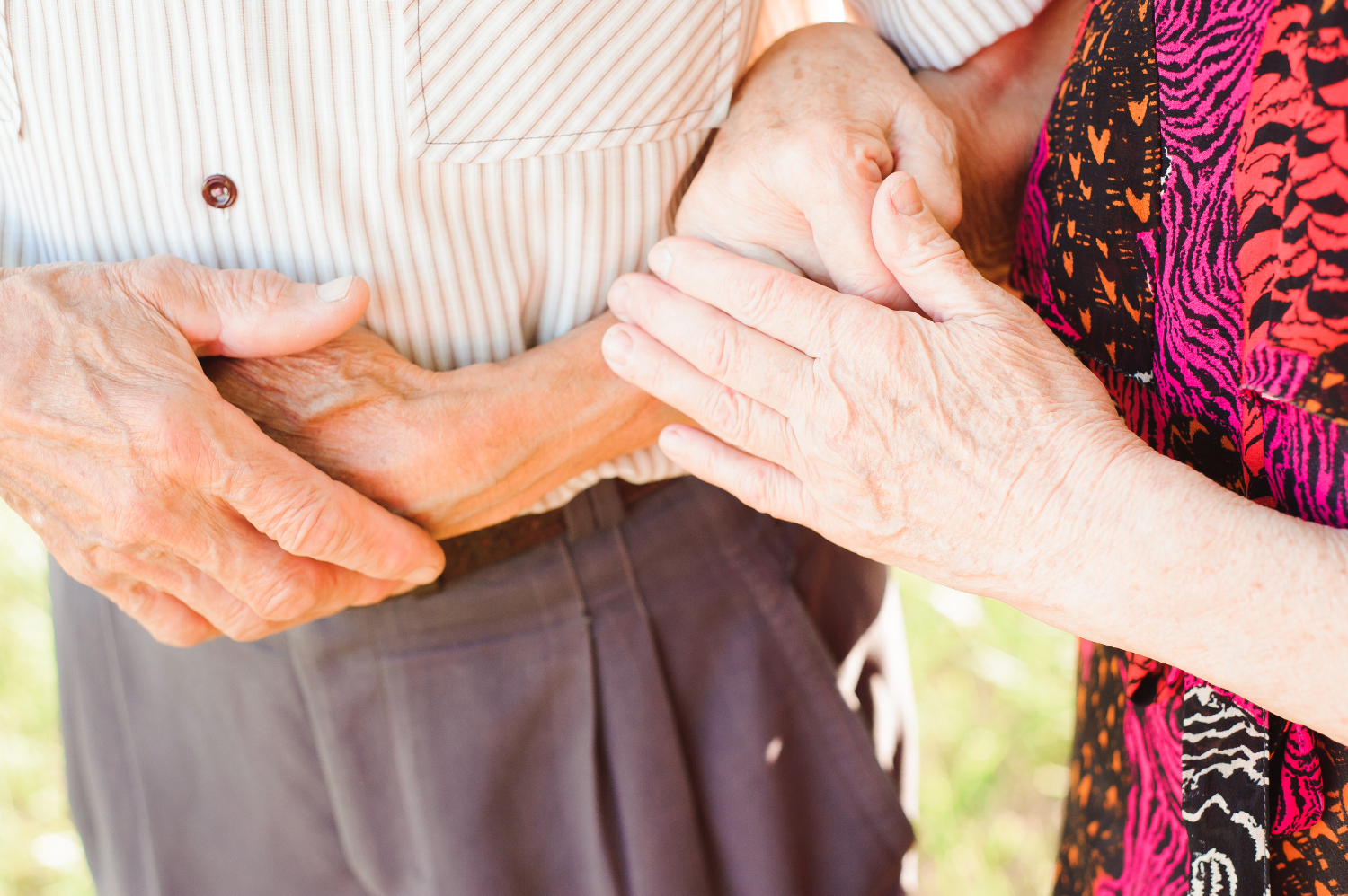 Nærbillede af en ældre mand og kvinde, der holder i hinandens arme.