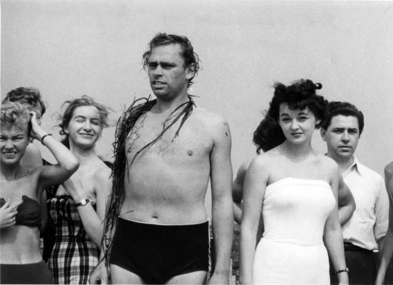 6 personer står i badetøj, Dirch Passer står i Midten med tang om halsen.
